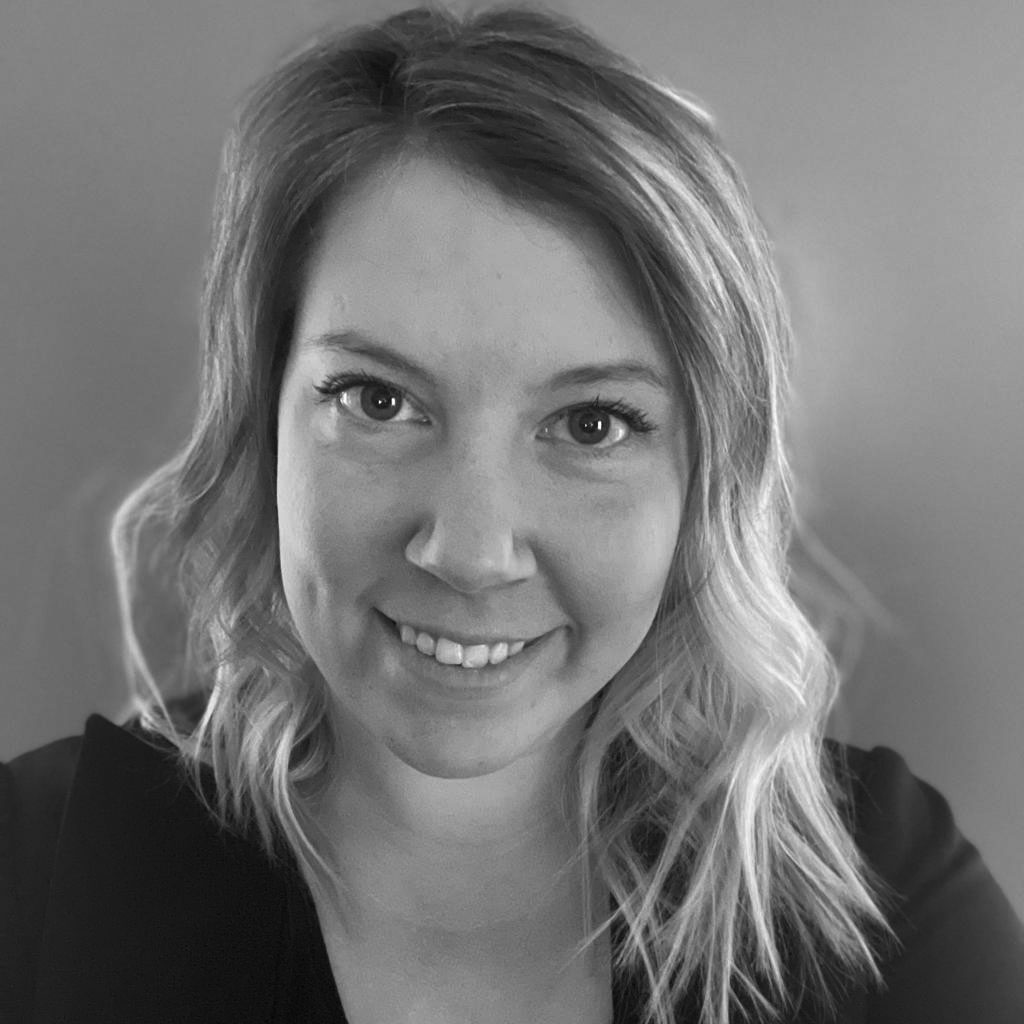 Black-and-white portrait of smiling woman with wavy hair