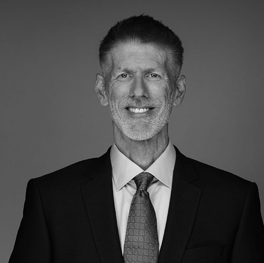 Smiling man in suit against plain background