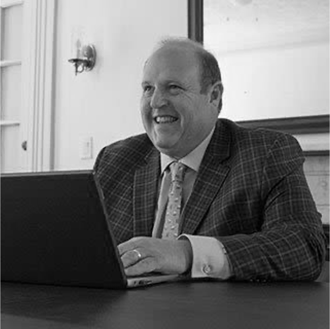 Smiling businessman working on laptop at desk