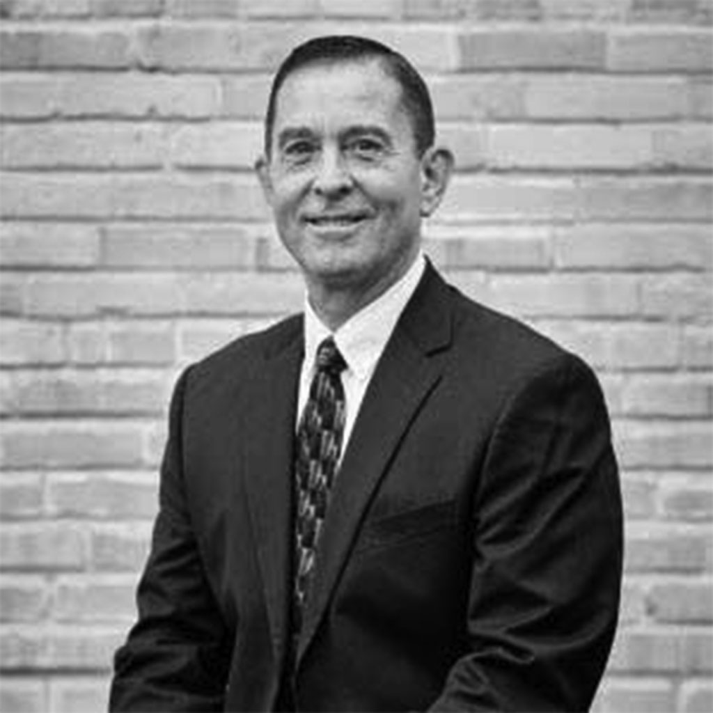 Smiling man in suit against brick wall