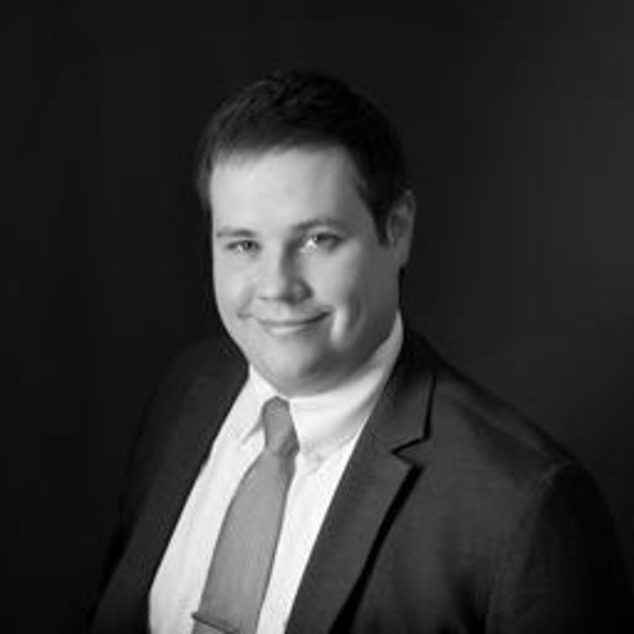 Black and white portrait of smiling man in suit