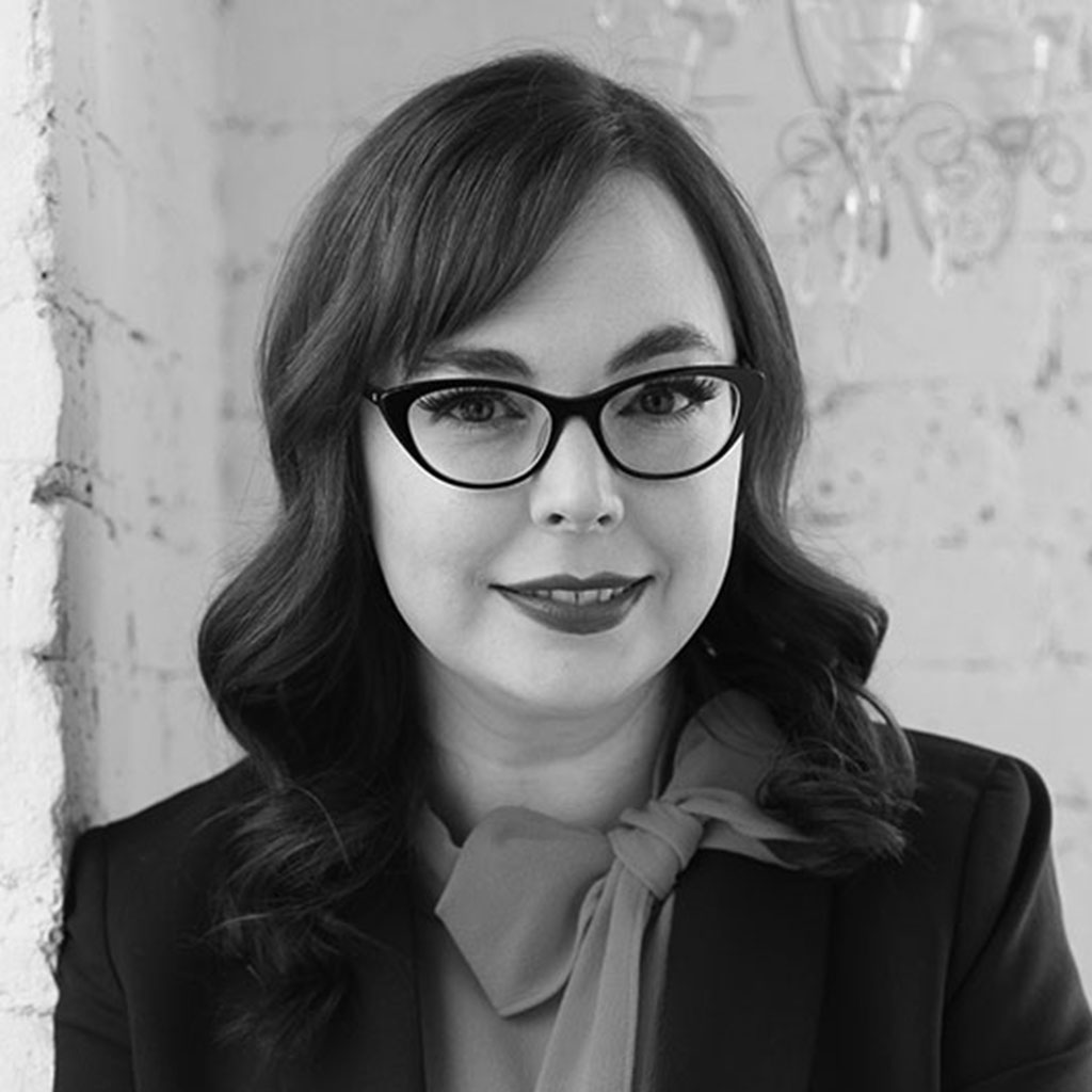 Black-and-white portrait of woman wearing cat-eye glasses