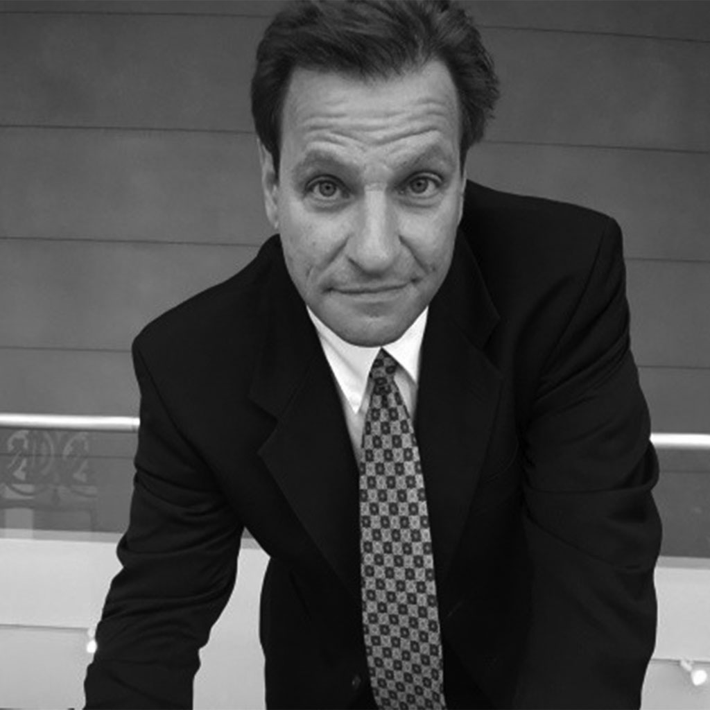 Black-and-white portrait of man in suit leaning forward