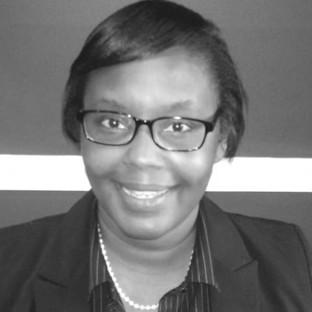 Smiling woman wearing glasses and blazer portrait