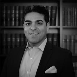 Man in suit smiling before bookshelf background
