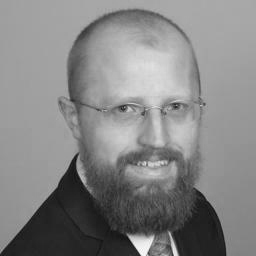 Smiling bearded man with glasses, grayscale portrait