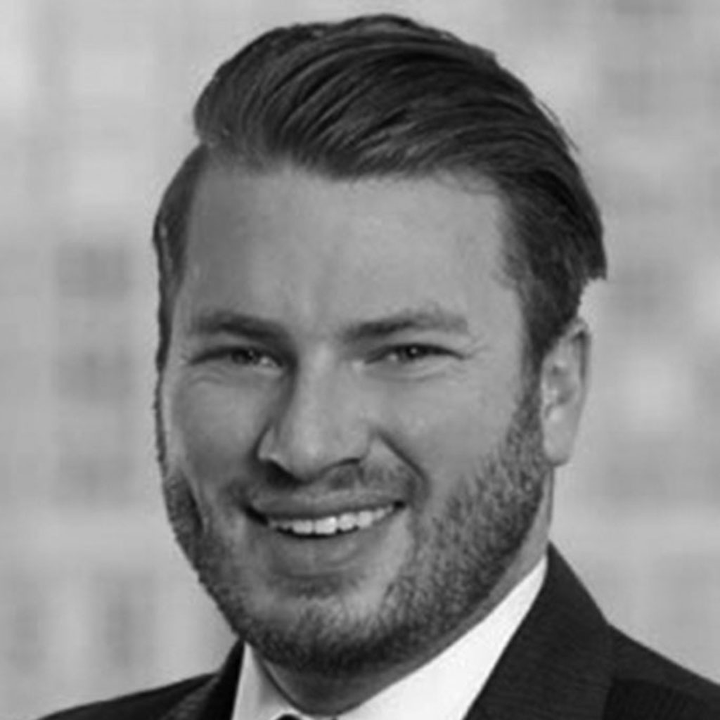 Black-and-white headshot of smiling bearded man