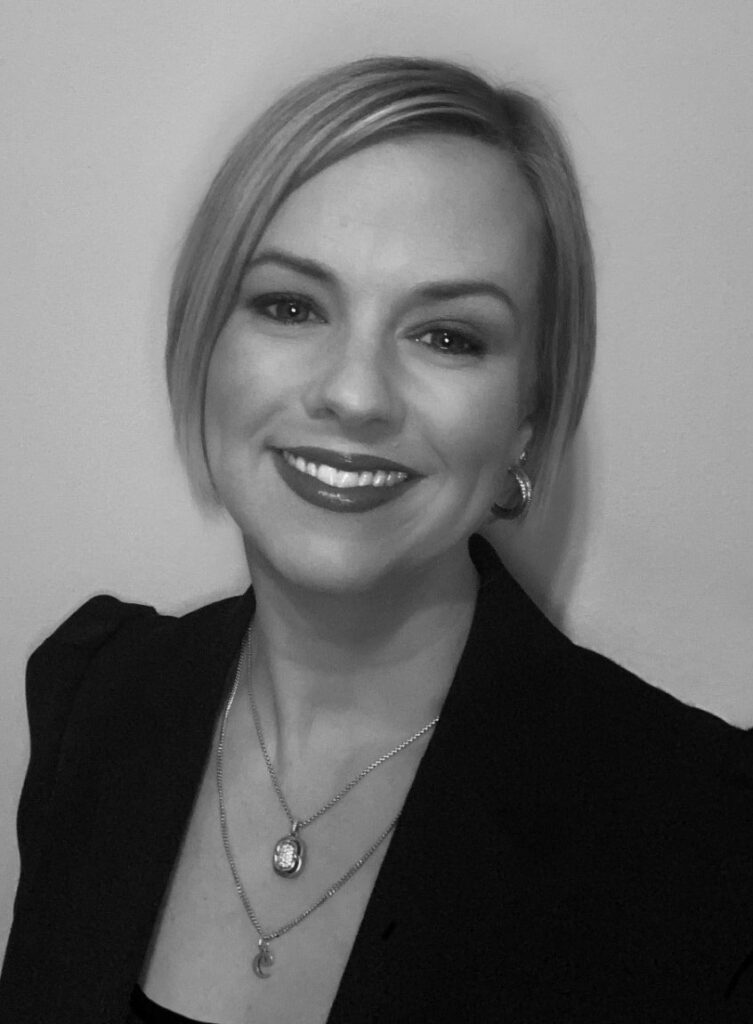 Black-and-white portrait of smiling woman in blazer