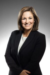 Professional woman smiling in dark blazer headshot