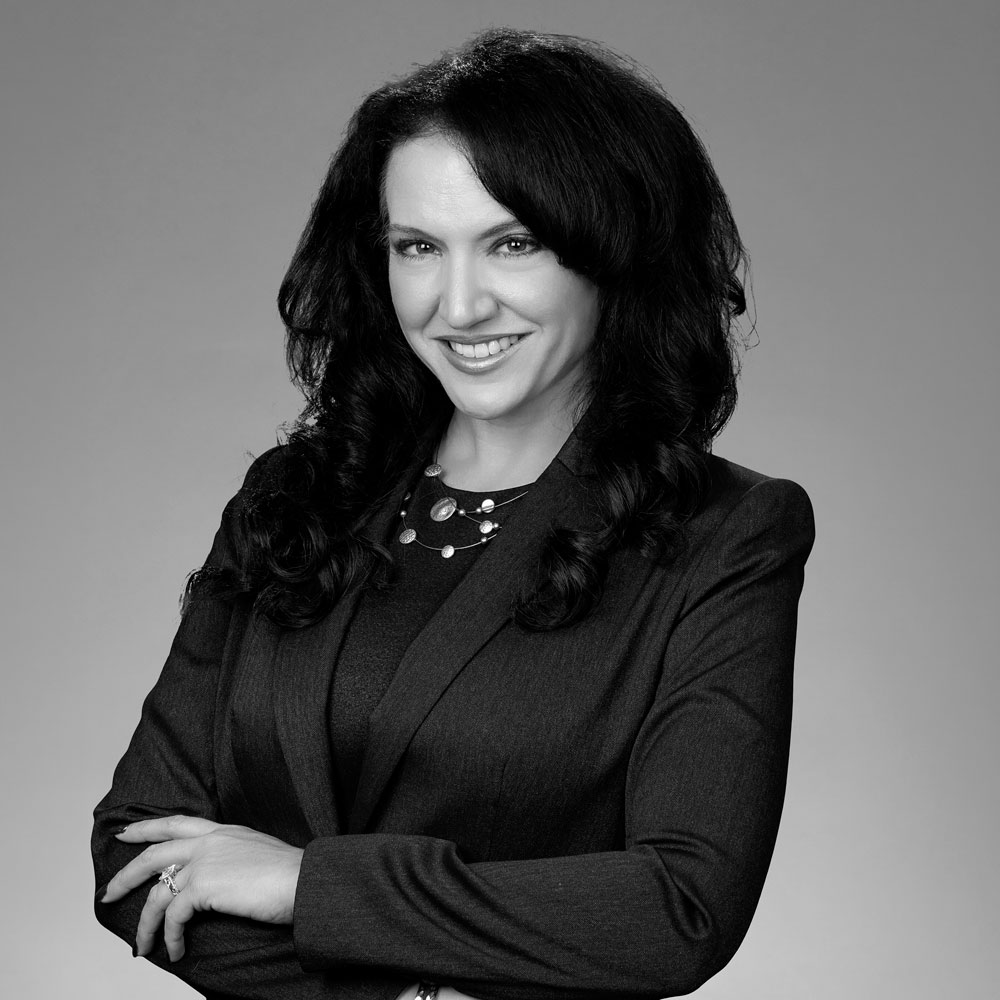 Black-and-white portrait of smiling woman in blazer