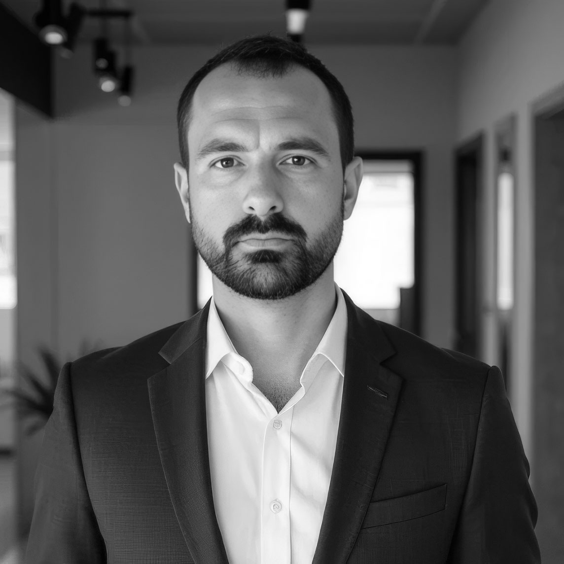 Black-and-white portrait of bearded man in suit