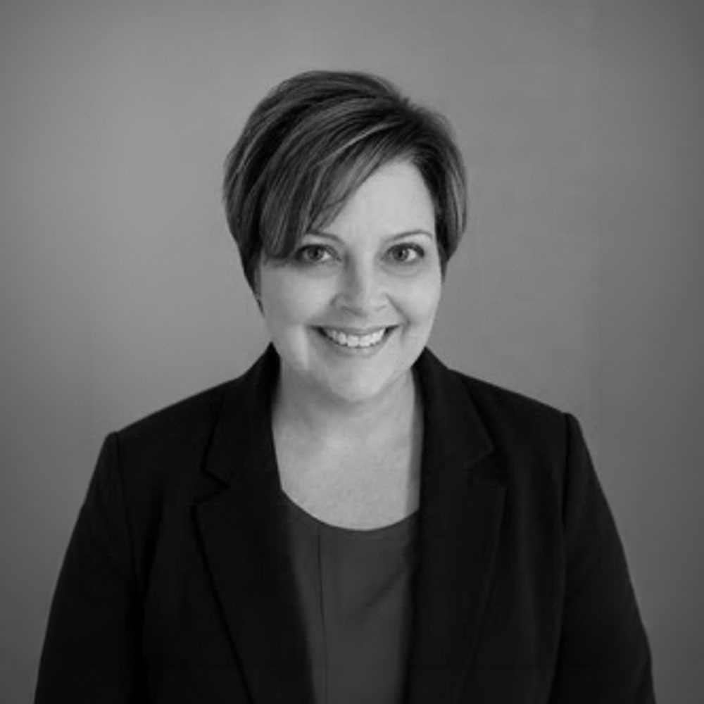 Black-and-white headshot of smiling woman in blazer