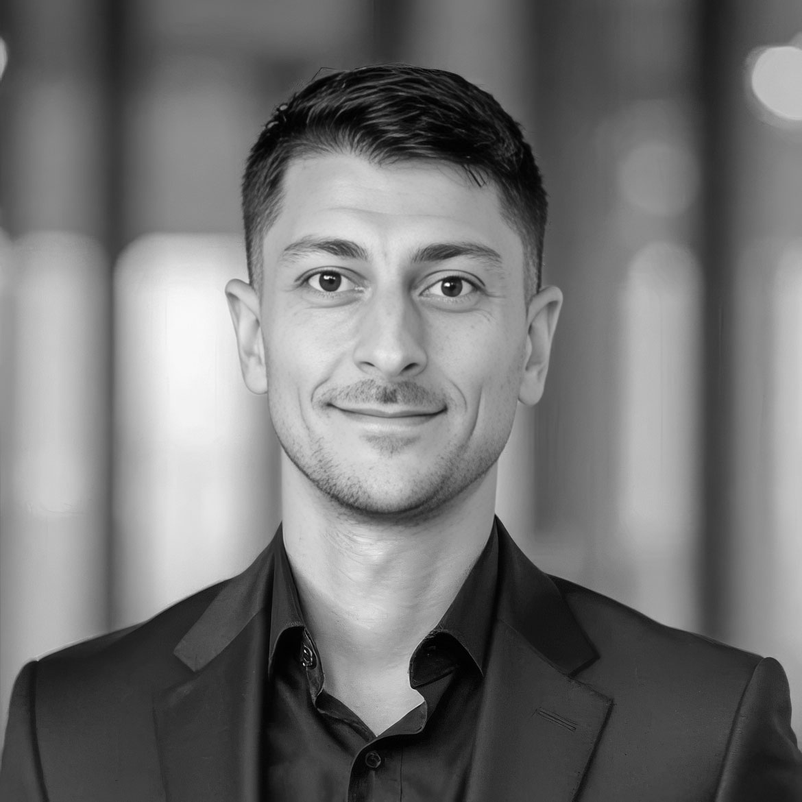 Black-and-white professional headshot of man in suit